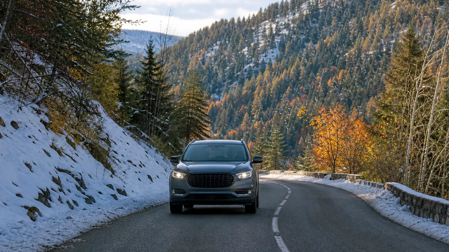 Une voiture sur une route de montagne bordée de neige.